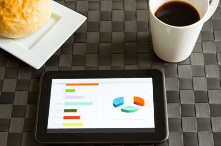 Working, analyzing graphics with the tablet and having breakfast
の写真素材