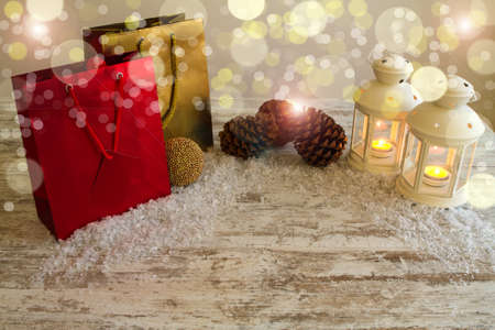 Christmas setting with candles, pine cones, shopping bags and baubles.の写真素材