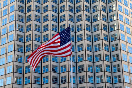 A flattering USA flag in front of a buildingの写真素材