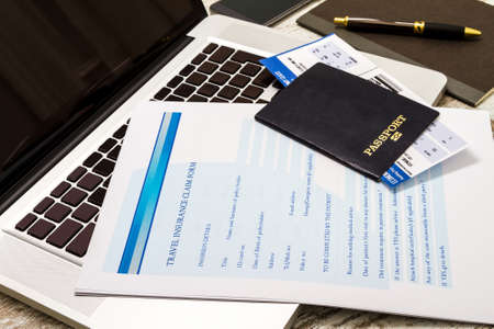 Travel insurance application form with a boarding pass and a passportの写真素材