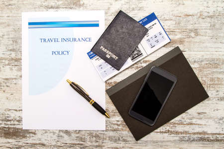 Travel insurance policy booklet with a boarding pass and a passportの写真素材