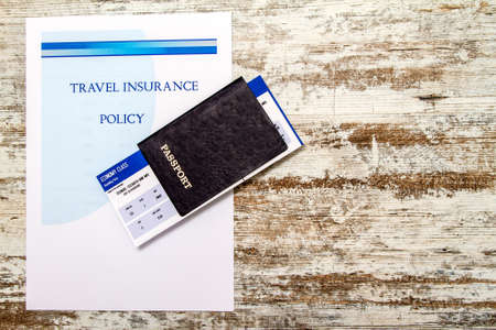 Travel insurance policy booklet with a boarding pass and a passportの写真素材