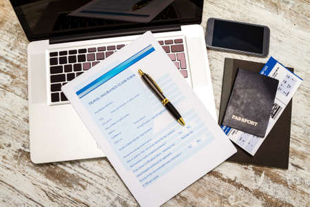 Travel insurance application form with a boarding pass and a passportの写真素材