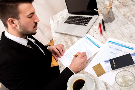 Travel insurance application form with a boarding pass and a passportの写真素材