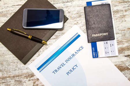 Travel insurance policy booklet with a boarding pass and a passport