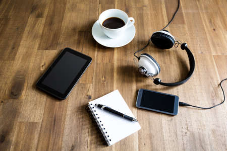 Working with the tablet, taking notes and drinking a coffeeの写真素材