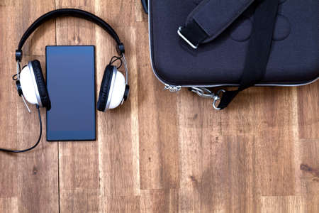 Cellphone with headphone and a briefcase background