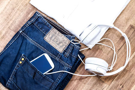 Informal male outfit with cellphone and headphone, backgroundの写真素材