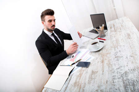 Working at the office with the laptop and some documentsの写真素材