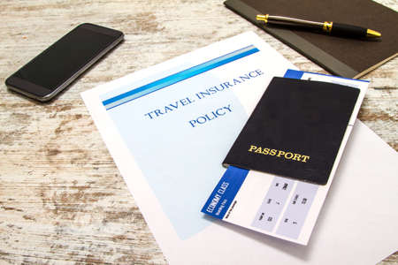 Travel insurance policy booklet with a boarding pass and a passportの写真素材