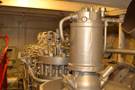 The mechanical workings inside the engine room of a rather large ship 