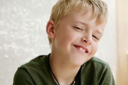 Close-up of a smiliing blond boy looking at camera
