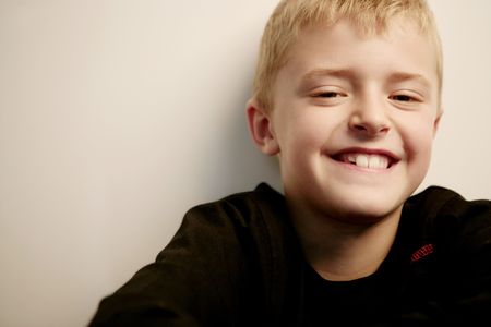 Close-up of a smiliing blond boy looking at camera