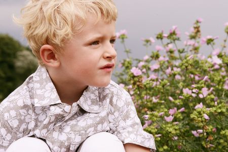 Close-up topless of a small blond cute boy dreaming in natureの写真素材