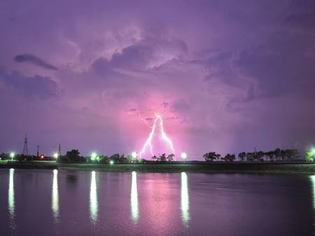 Lightning over lake at summer nightの写真素材