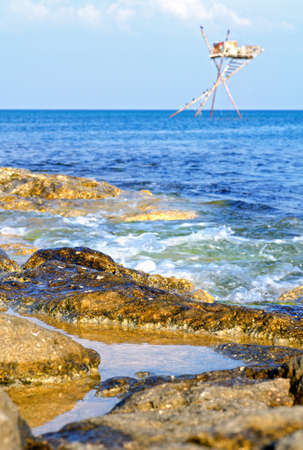 Clear water at sea coast. The wave runs on coastal rocks.の写真素材