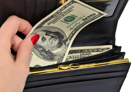 Female hand takes the dollar bill one hundred dollars from a black purse. Isolated on a white...