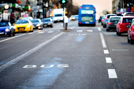 Bus in bus lane out of focus, traffic. Bus sign painted on street in focus.の写真素材