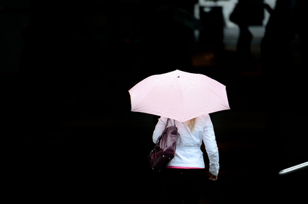 Woman with umbrella against blackの写真素材
