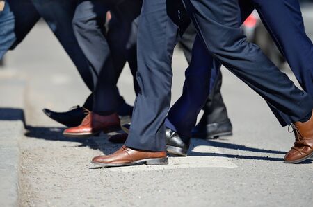 Suits crossing streetの写真素材