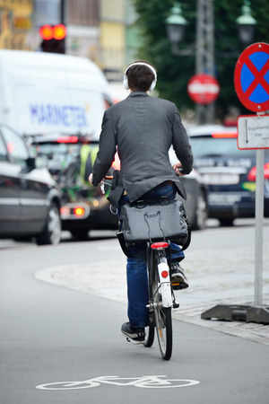 Male bicyclist on the street, with headphonesの写真素材