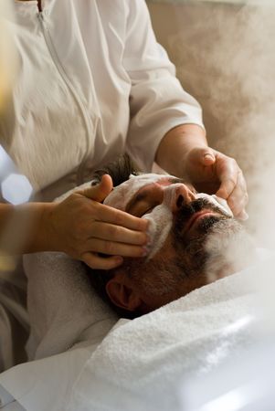 Older man getting full facial at spaの写真素材