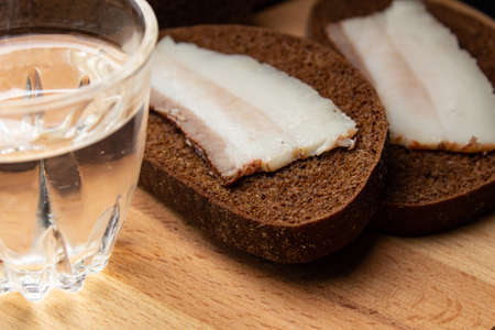 Lard with black bread and a shot glasses with alcoholの写真素材