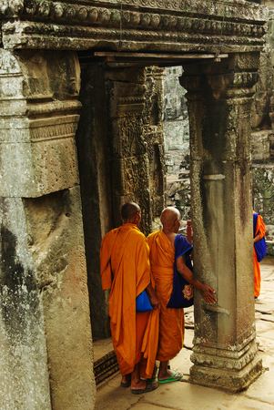 Buddhist monks at a temple in Angkor Wat, Cambodia, sightseeing at ancient tourist attraction, walking along old pillarsのeditorial素材