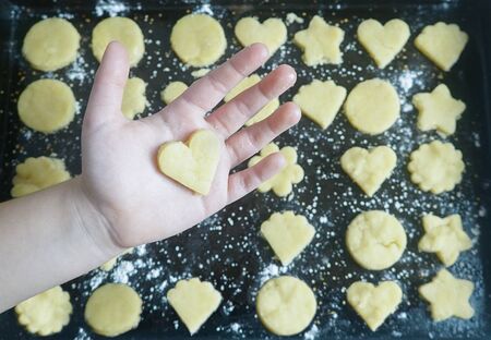 HAND WITH COOKIE HEART ON TRAY_