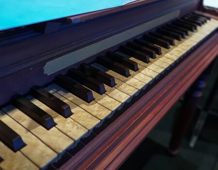old wooden piano with notoriously aged keys and stained by timeの写真素材