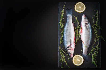 fresh seabass, lemon and spices on the tableの写真素材