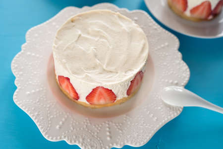Summer strawberry mousse cake with fresh berries on the wooden blue background top viewの写真素材