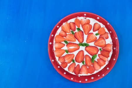 Strawberry cake with sour cream on a blue background top viewの写真素材