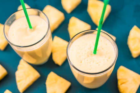 pineapple smoothie on a blue background top viewの写真素材