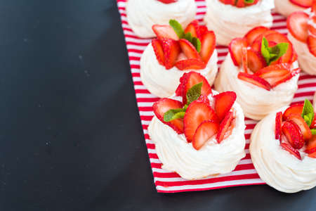 Homemade small strawberry pavlova meringue cakes pattern with cream top viewの写真素材