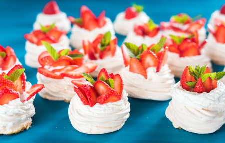 A small meringue Pavlova dessert with some strawberry slicesの写真素材