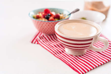 Healthy breakfast - cup of coffee, muesli and fresh berries on white wooden background, top view, health and diet conceptの写真素材