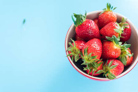 close view of somefresh strawberries in a brown bowl isolated