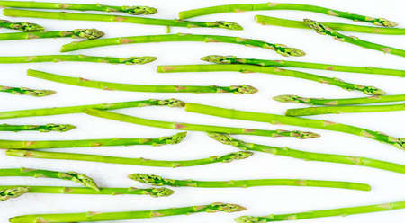 Fresh green asparagus shoots pattern, top view. Isolated over white. Food background asparagus flat lay patternの写真素材