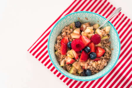 Healthy breakfast - oatmeal with strawberry and fresh berries on white wooden background, top view, health and diet conceptの写真素材