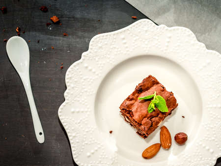 Homemade chocolate brownies on a white porcelain plate on wooden background closeup, top viewの写真素材