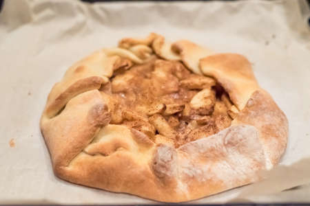 Homemade apple pie on parchment paper only from the ovenの写真素材