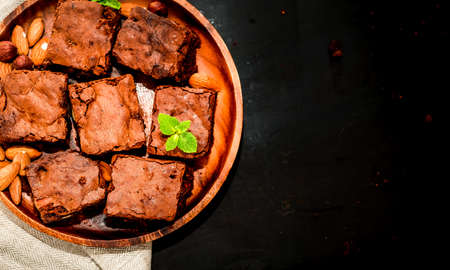 brownie chocolate cake on a wooden plate top view, space for textの写真素材
