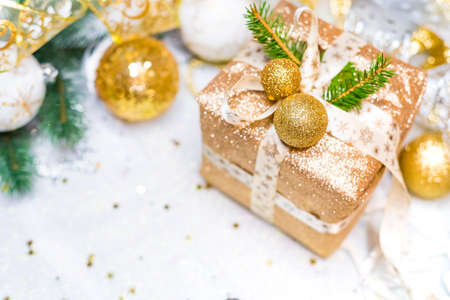 New Years gift in a golden box, decorated with bart, Christmas tree branches and Christmas toysの写真素材