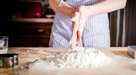 Making dough by female hands at bakery