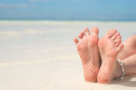 Bare feet on the sandy white beach.の写真素材