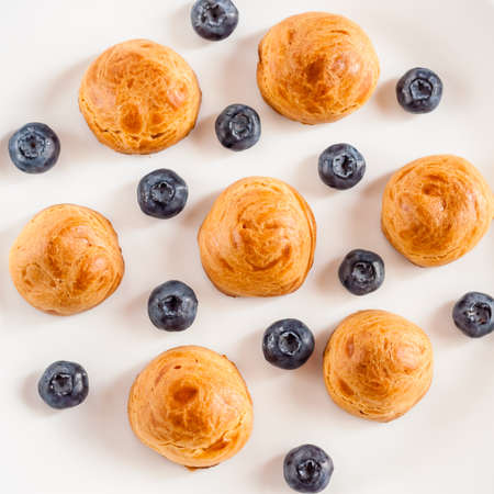 Delicious profiteroles with cream on a plate.の写真素材