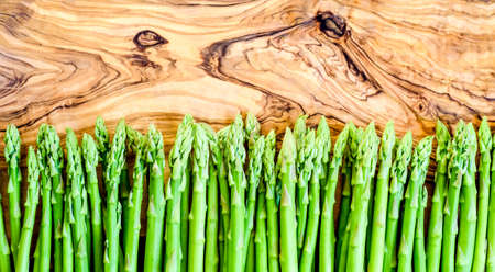 asparagus in a row, top view on a wooden board, copy spaceの写真素材