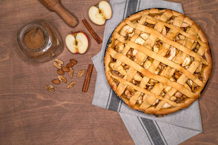 Fresh baked classic American apple pie with nuts and cinnamon on a wooden background. Top view, rustic style.の写真素材