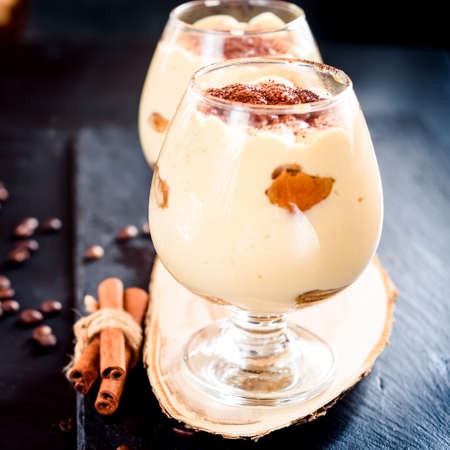 Traditional Italian dessert Tiramisu in a Glass Jar on Dark Background
